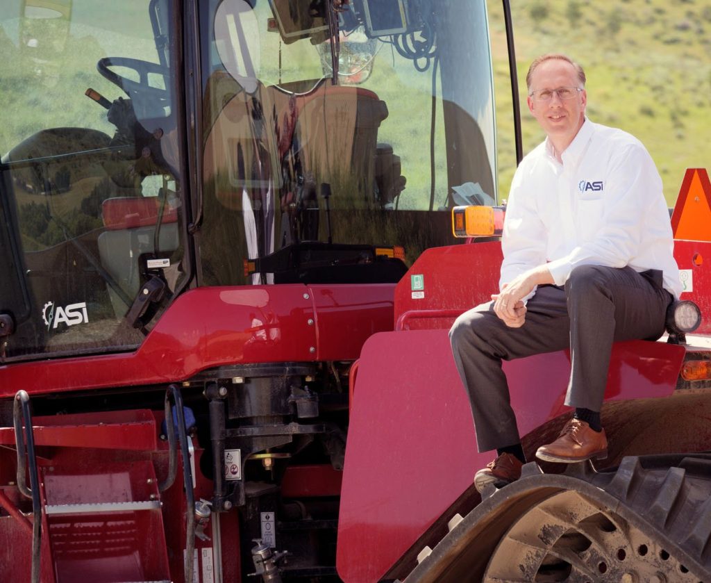 Mel Torrie posing on an autonomous agricultural tractor